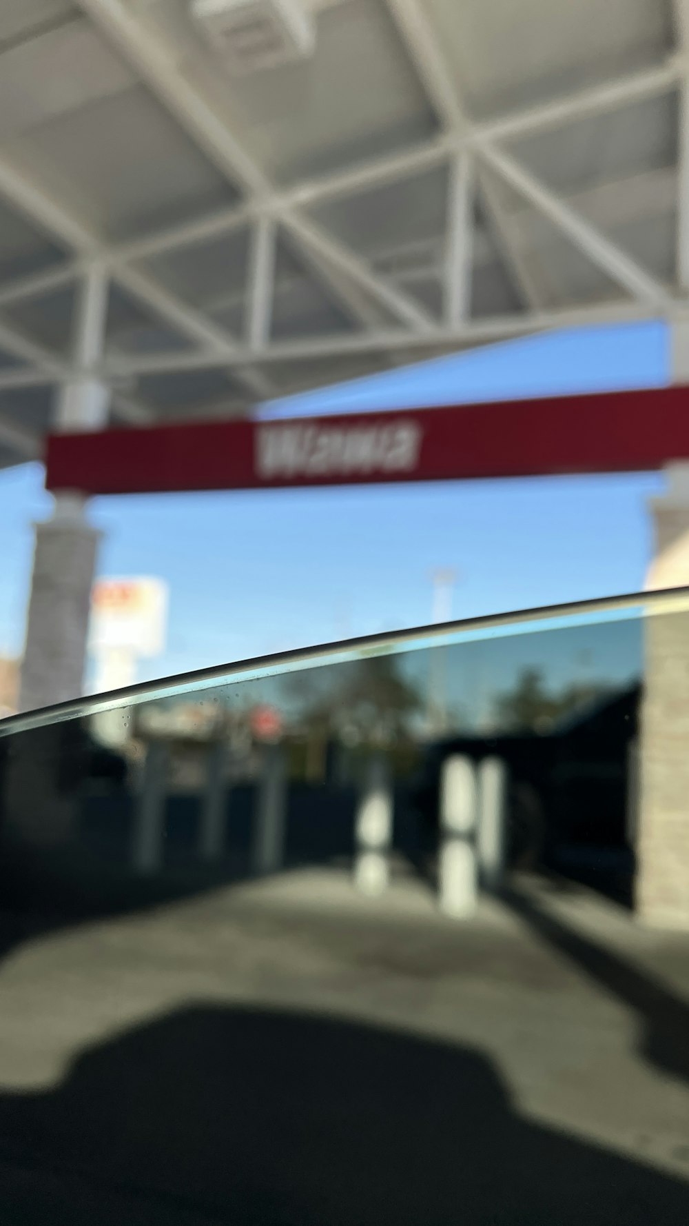 a close up of a car window with a street sign in the background