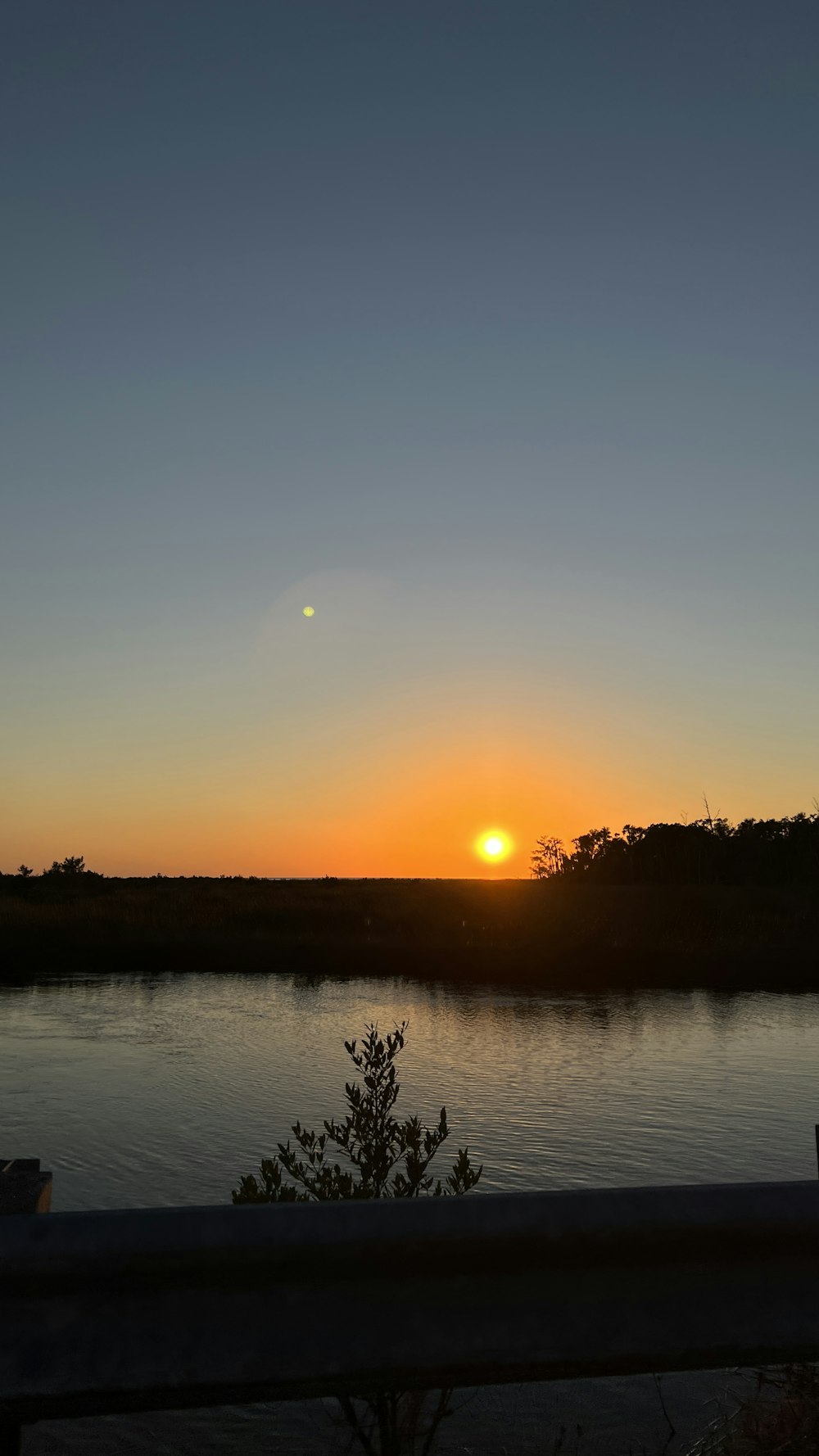 the sun is setting over a body of water