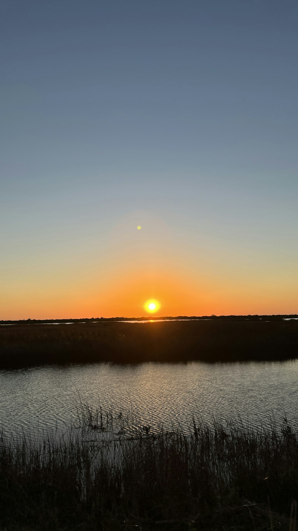 the sun is setting over a body of water