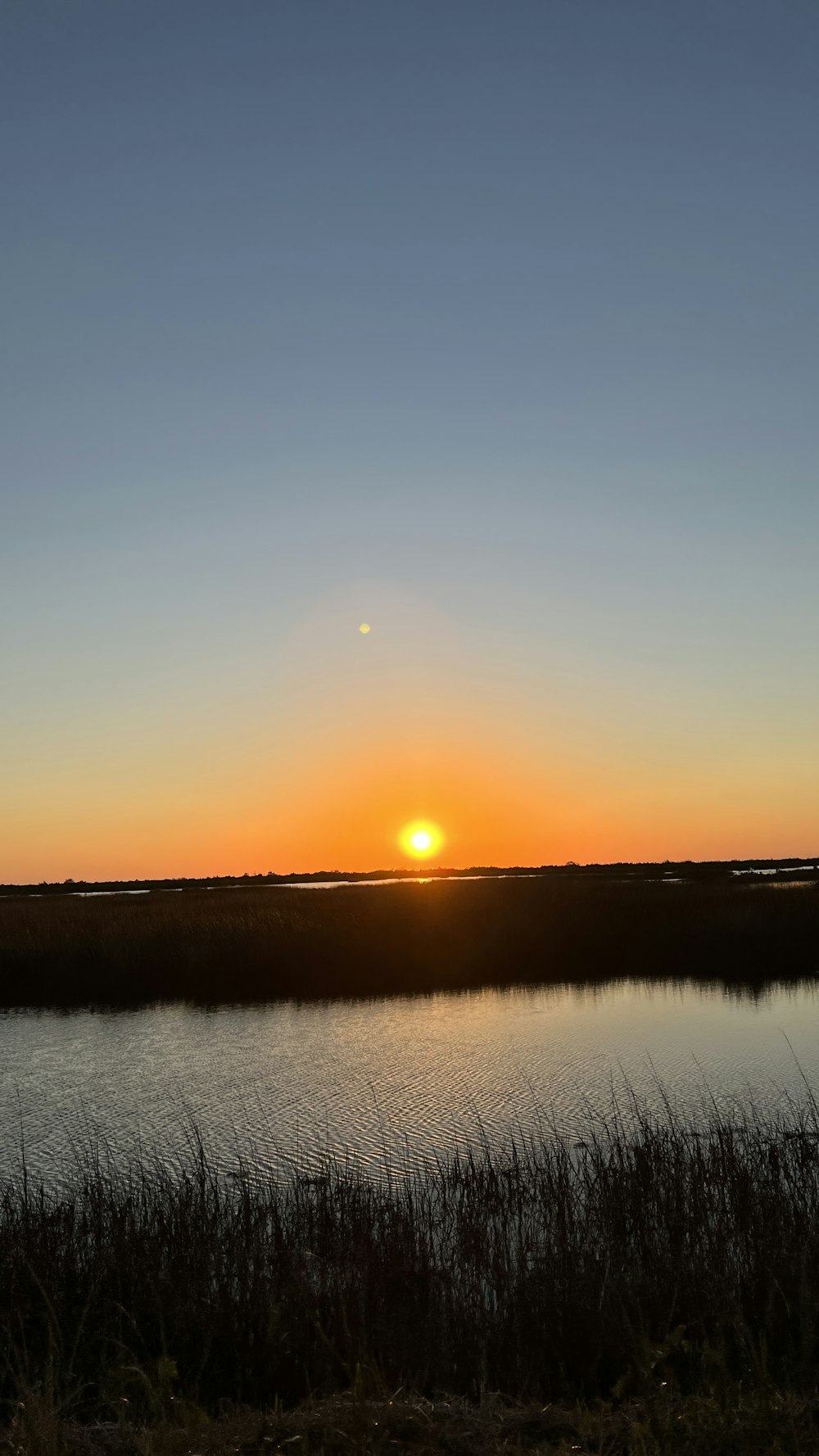 the sun is setting over a body of water