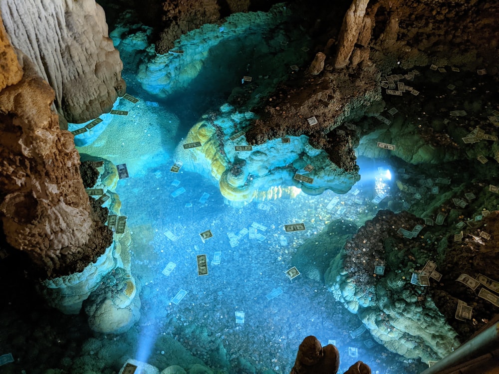 a person standing in a cave looking down at the water