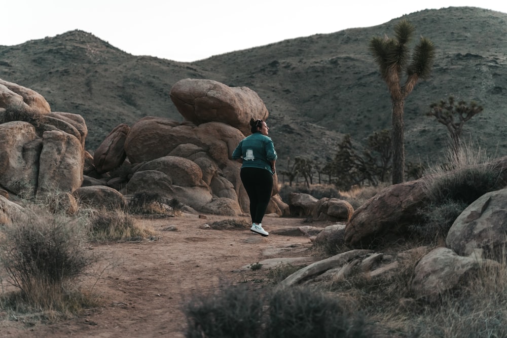 a woman running on a trail in the desert