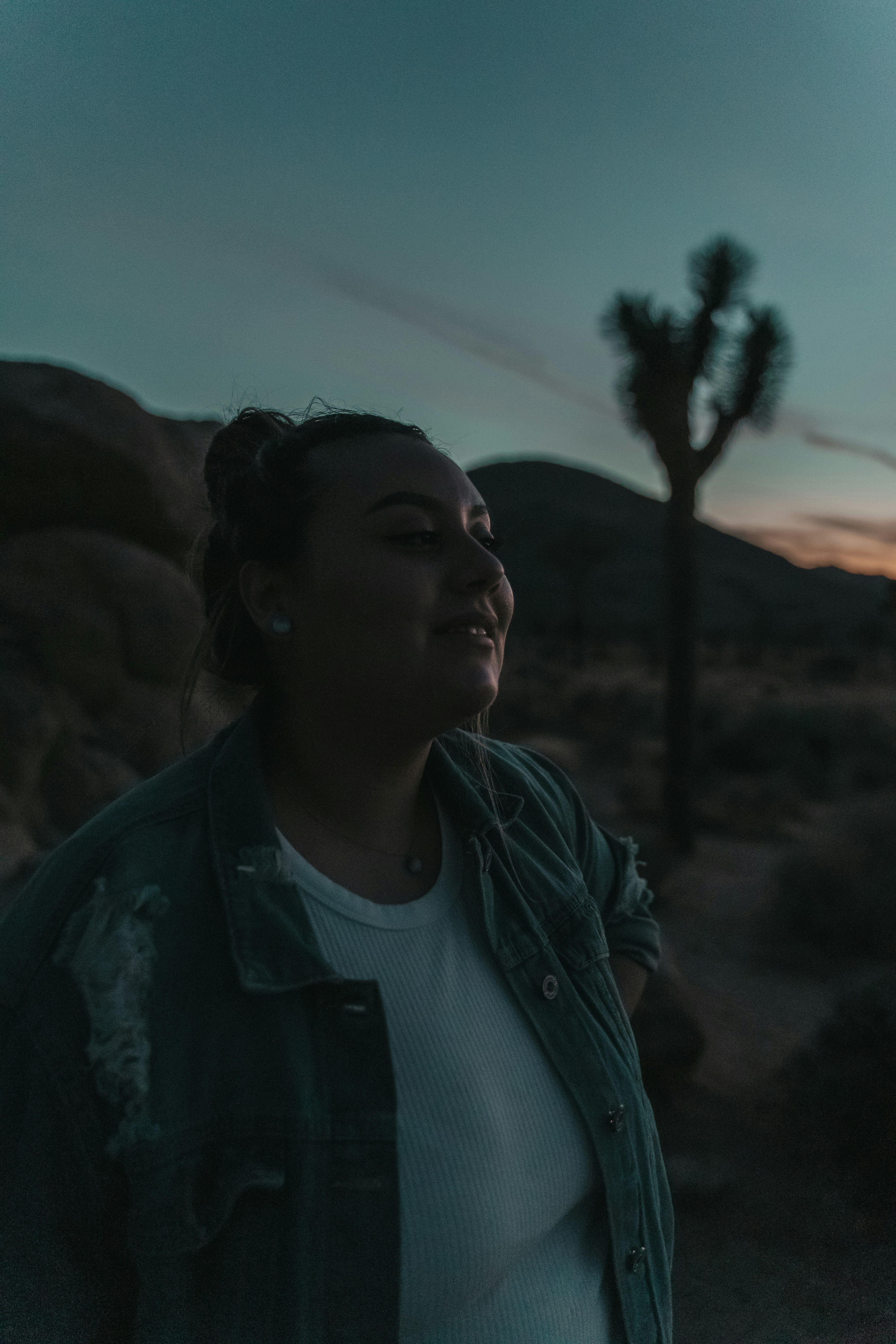 a woman standing in the desert at sunset
