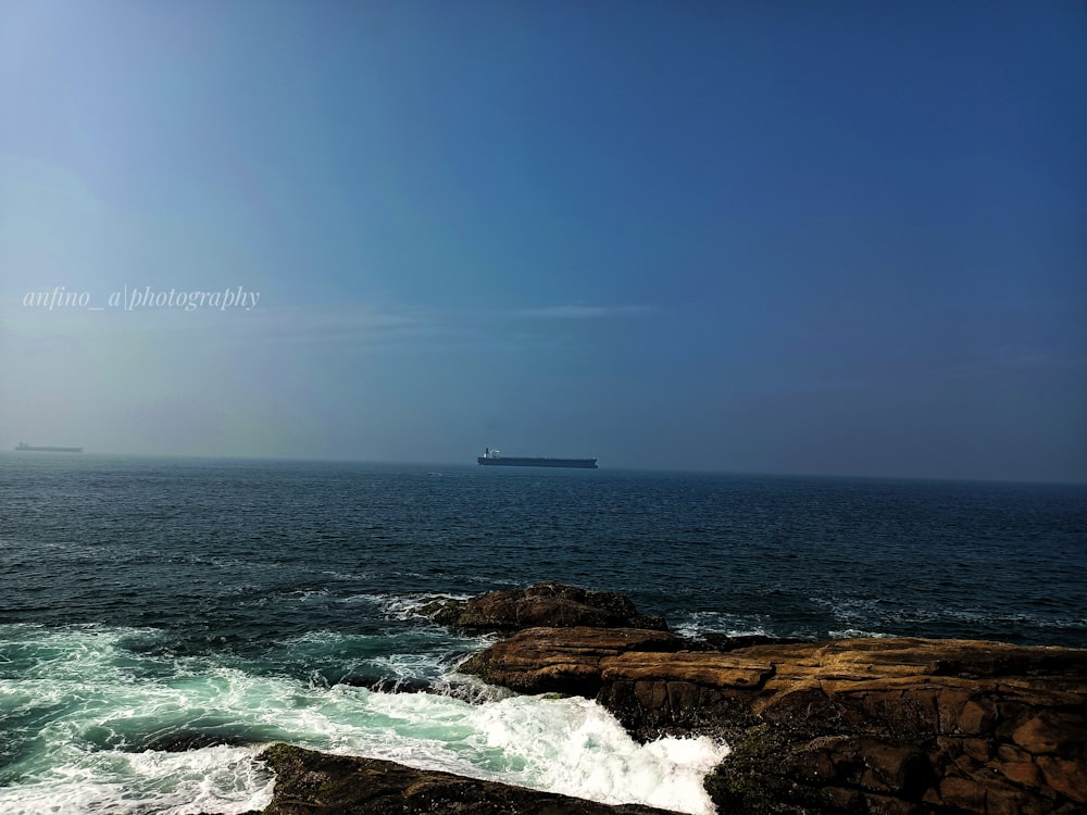 a large cargo ship is in the distance on the ocean