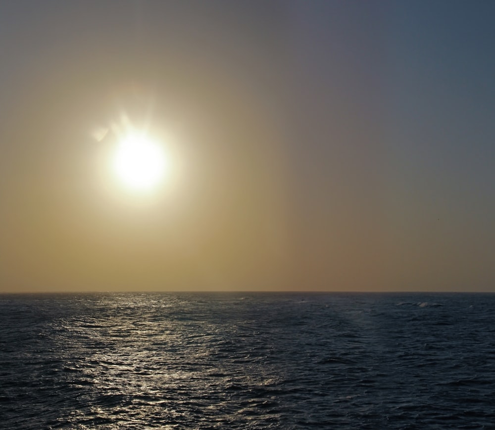 the sun is setting over the ocean on a clear day