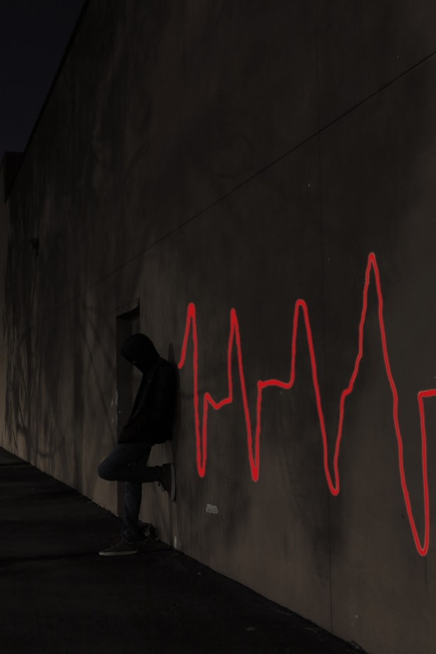 a man leaning in front of a wall with his lifeline on the wall