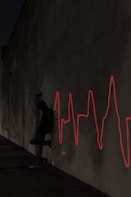 a man sitting on a skateboard in front of a wall