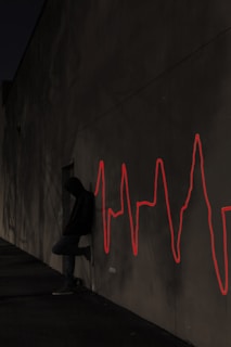 a man sitting on a skateboard in front of a wall