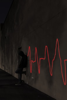 a man sitting on a skateboard in front of a wall