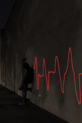 Model wearing the oversized graphic hoodie leaning against a graffiti-covered wall at night.