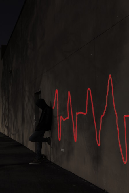 a man sitting on a skateboard in front of a wall