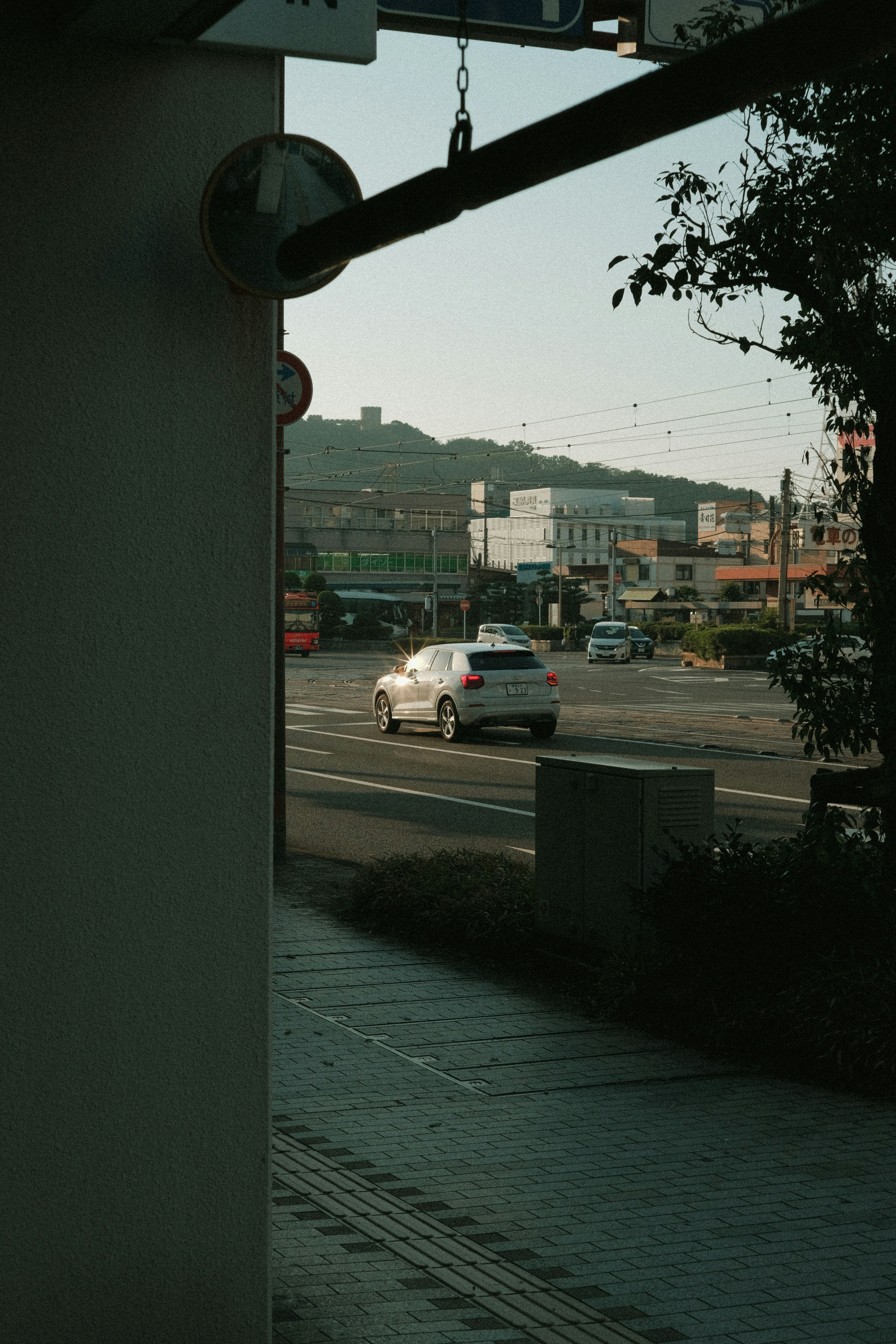 a white car driving down a street next to a tall building