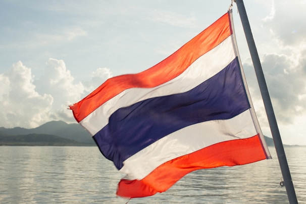 a thai flag flying over a body of water