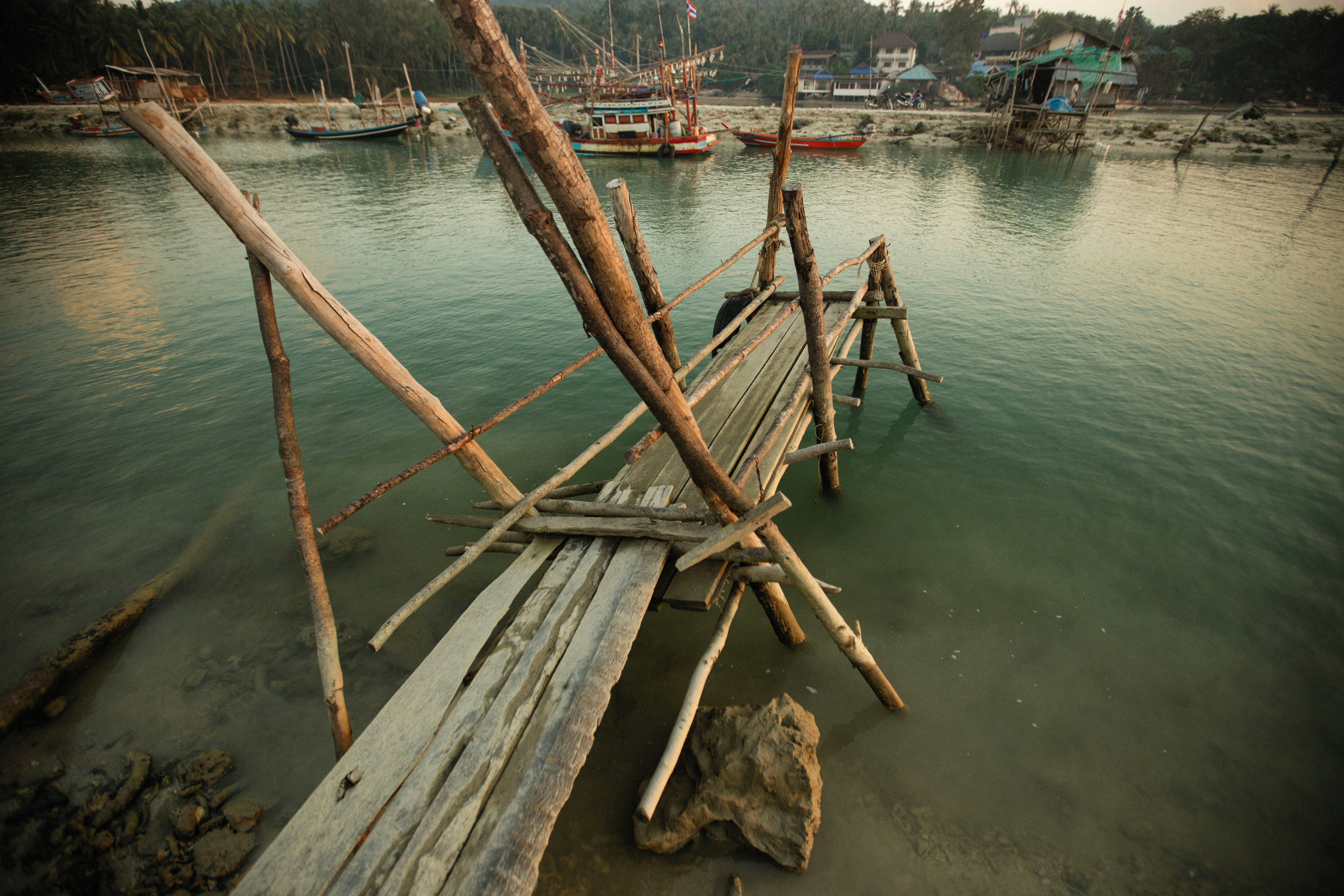 A dilapidated rural health center or a makeshift bridge made of logs, symbolizing the lack of proper infrastructure.