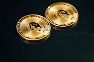 a close up of two gold coin on a black surface