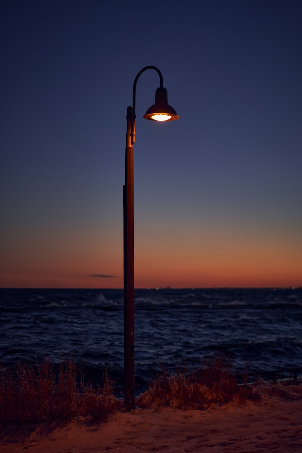 Una farola sentada al lado de una playa