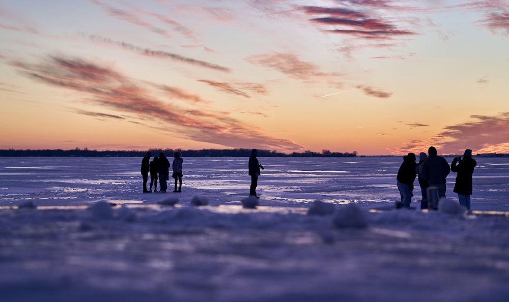 a group of people standing on top of a frozen lake