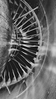 A close-up view of a turbine engine's fan blades with a metallic and industrial appearance. The image features the text 'NO STEP' on one of the blades, indicating sensitive areas that should not be walked on. The lighting accentuates the sleek, smooth surfaces and intricate details of the hardware.