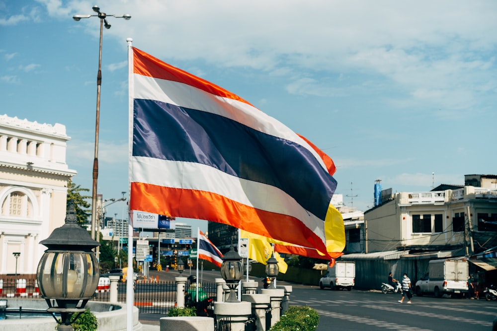 a flag flying in the wind on a city street