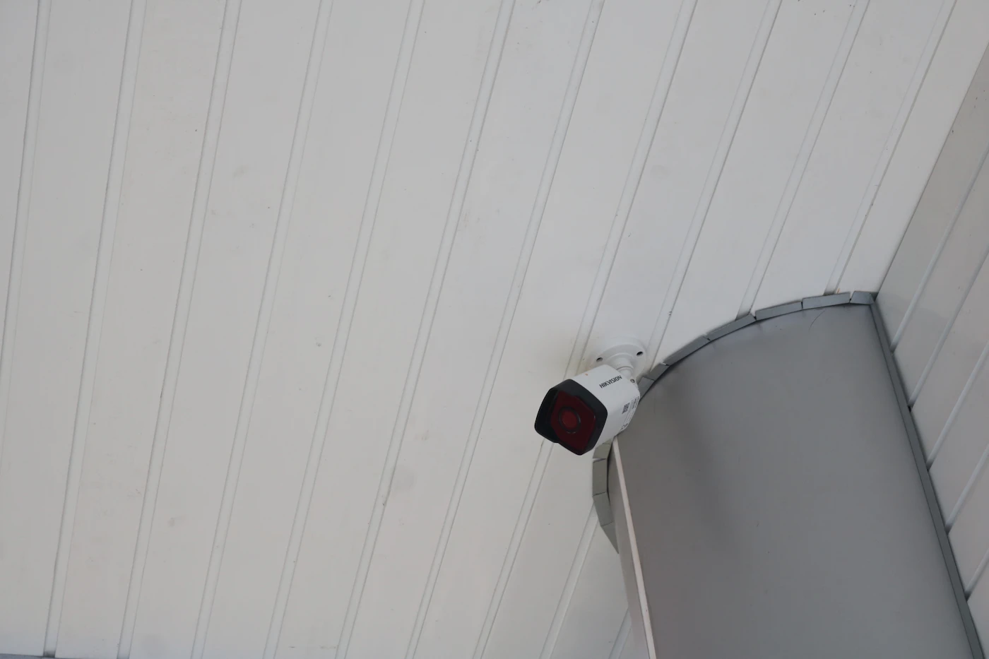 Security camera fixed to the side of a building wall