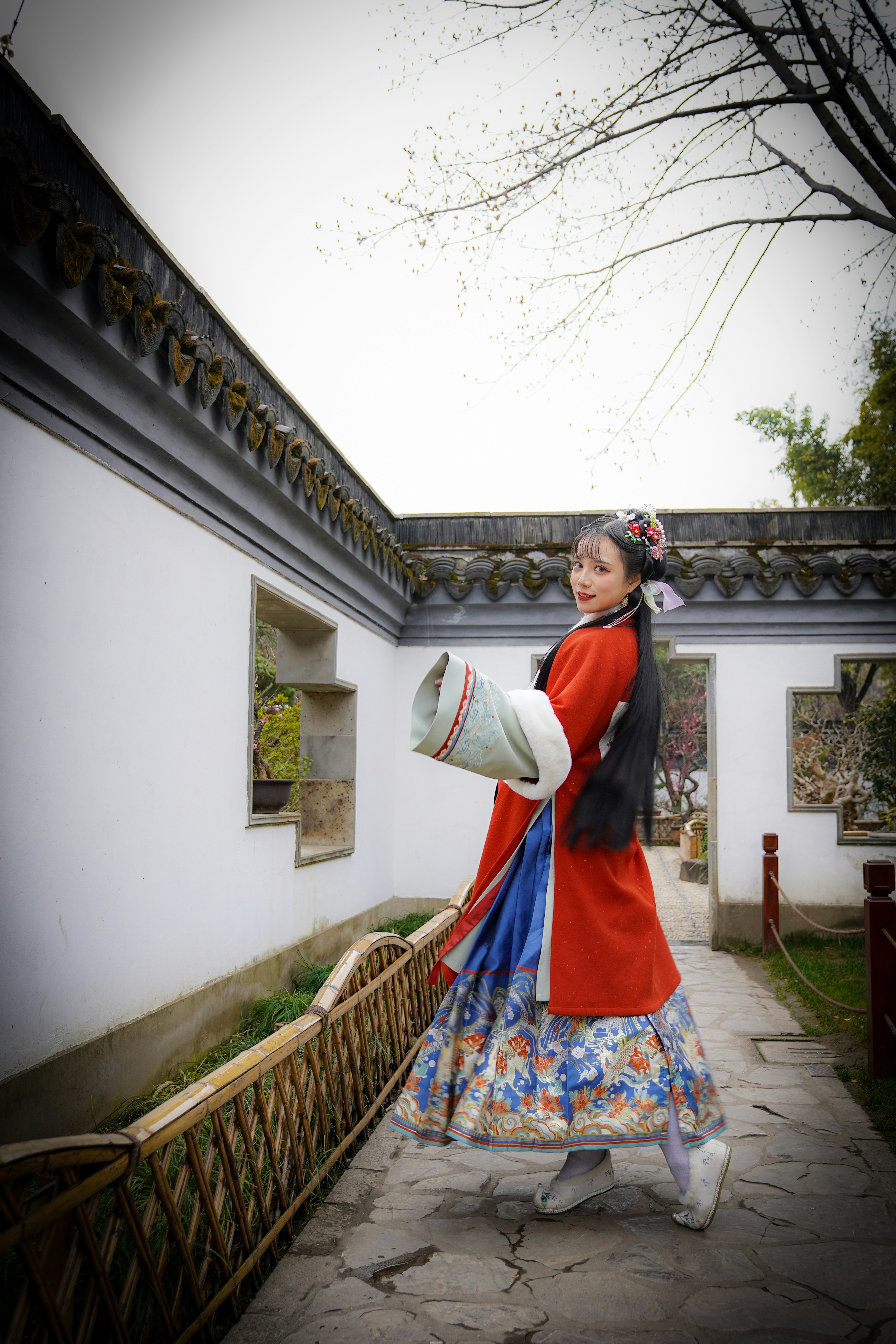 a woman in a red dress is holding a fan