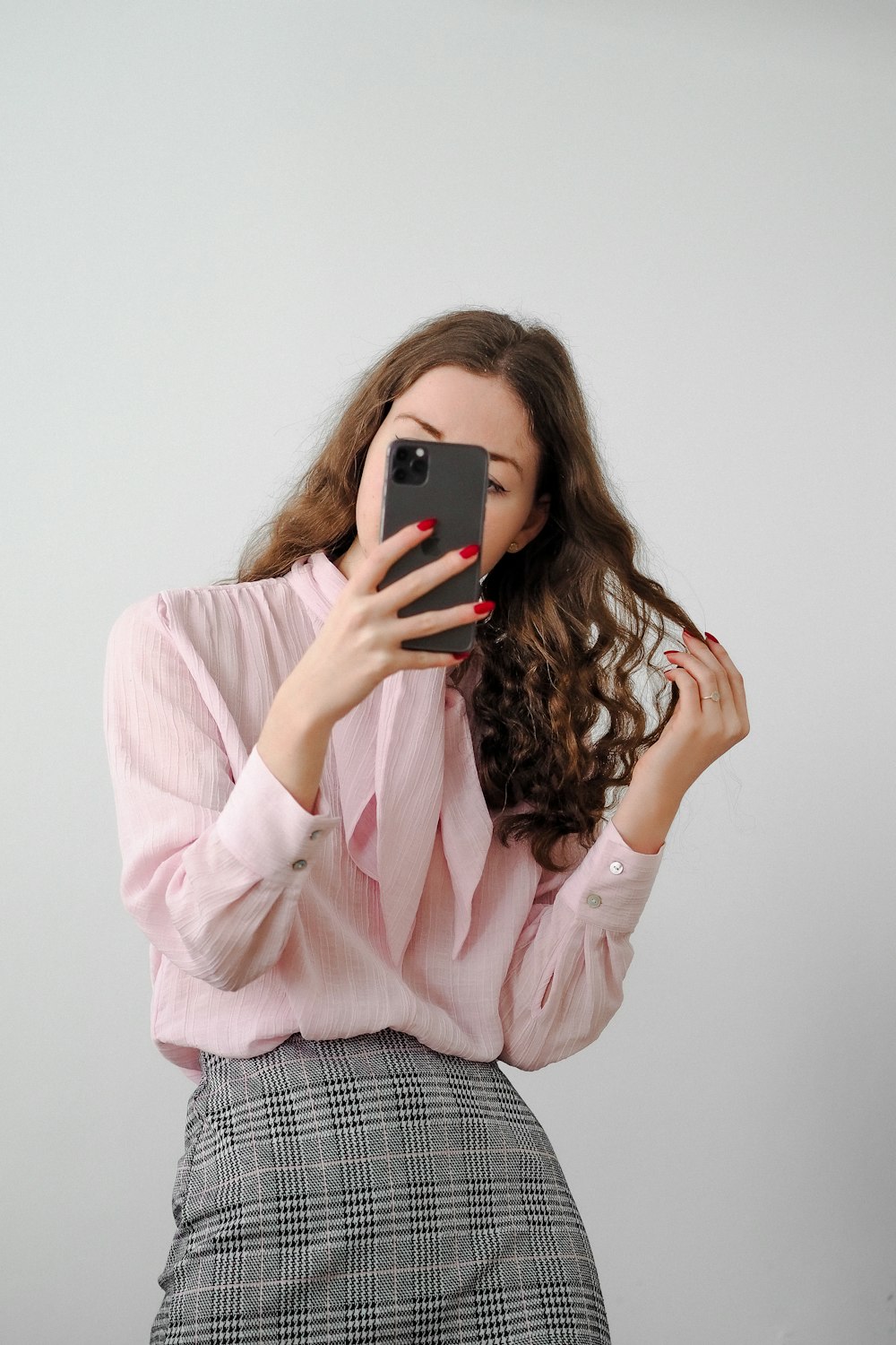 a woman taking a picture of herself with a cell phone