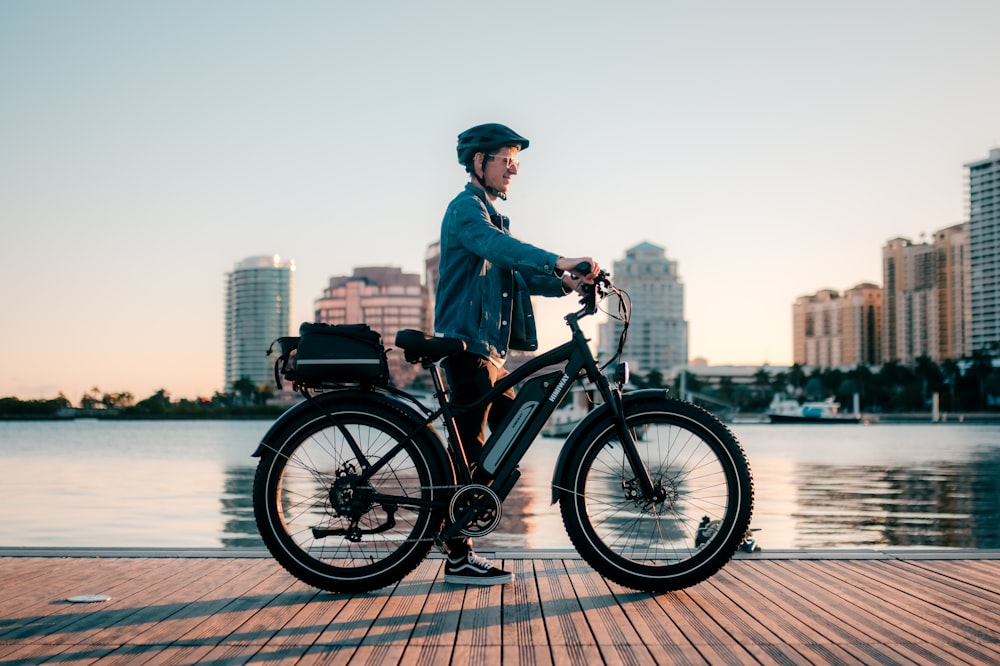 a man riding a bike on a wooden pier