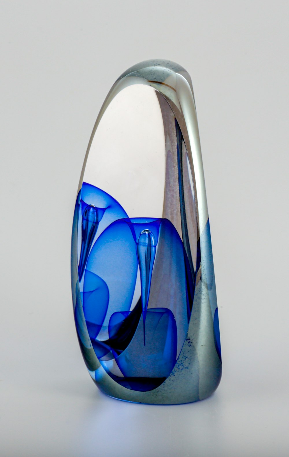 a blue glass vase sitting on top of a table