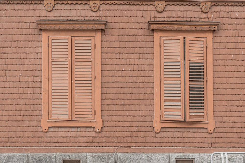 a red brick building with two windows and a bench