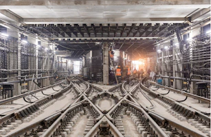 A team of engineers reviewing blueprints at a busy Los Angeles light-rail construction site.