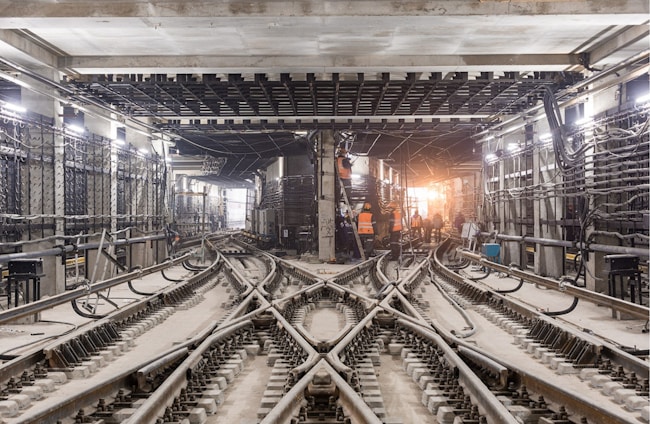 A team of railway engineers collaborating over technical plans in a modern office.