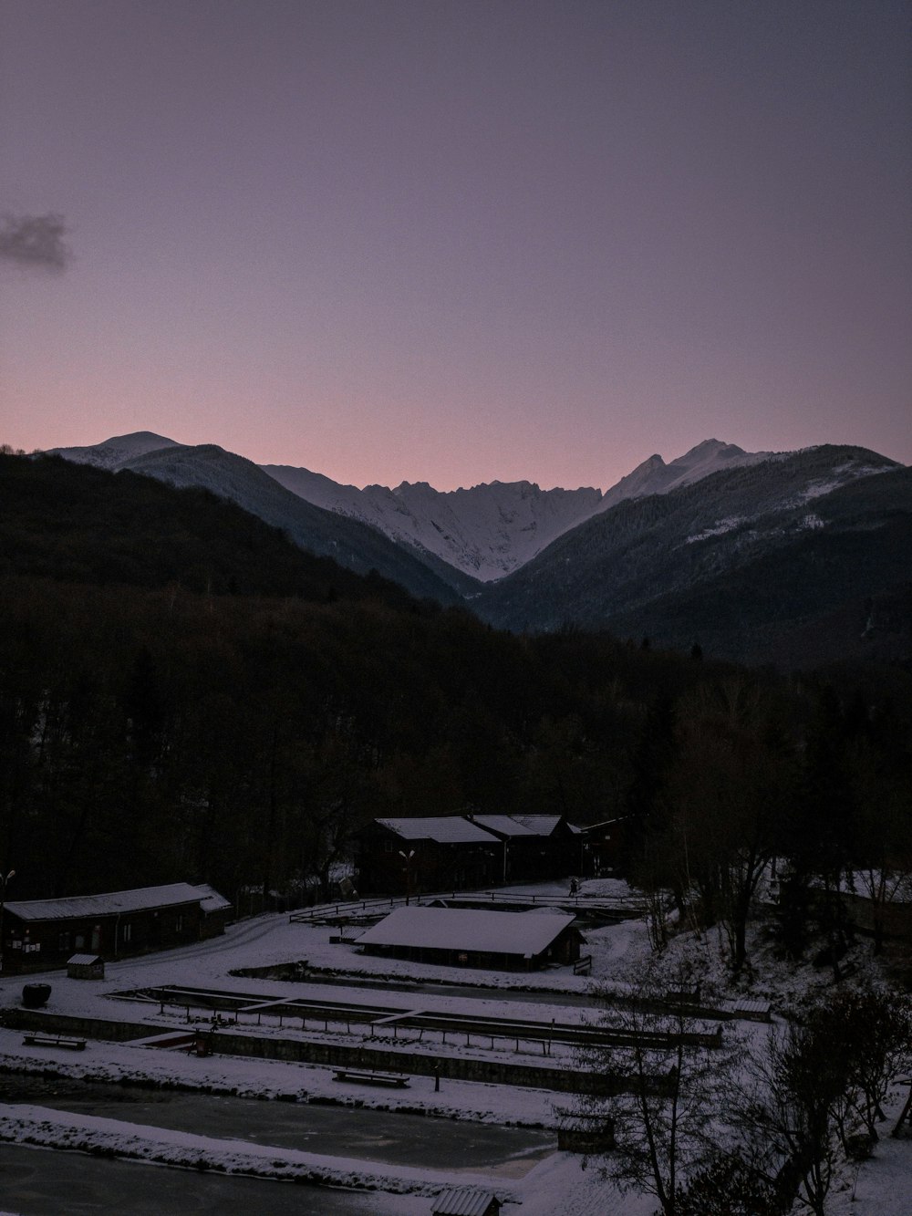 a snowy landscape with mountains in the background