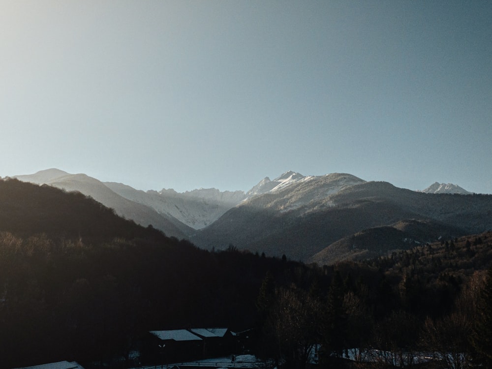 the sun shines on a snowy mountain range