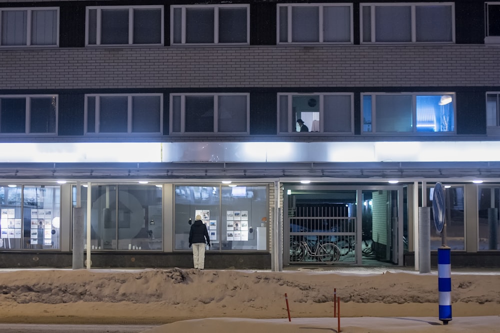 a person standing outside of a building at night