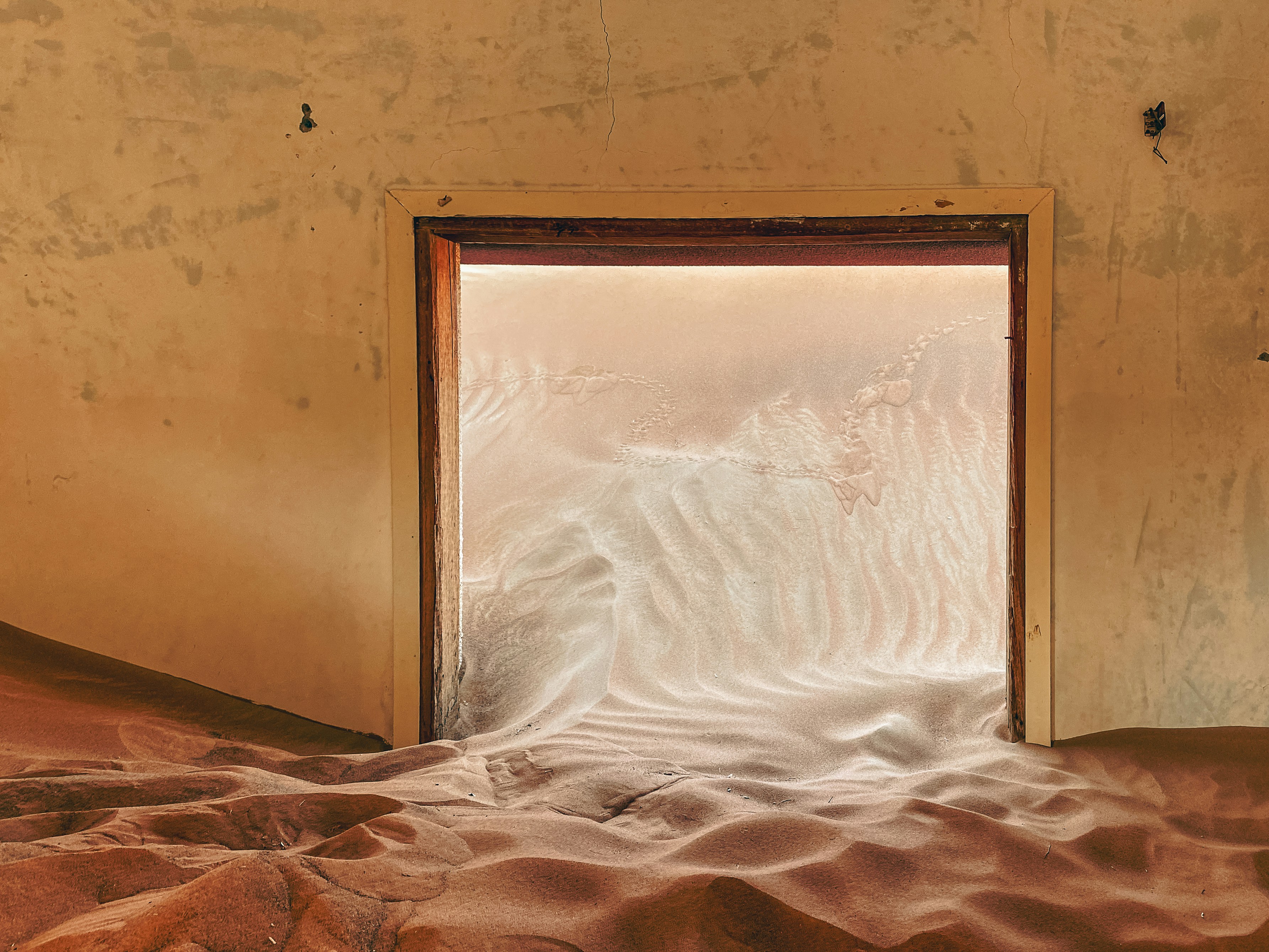 a window in a desert with sand in the foreground