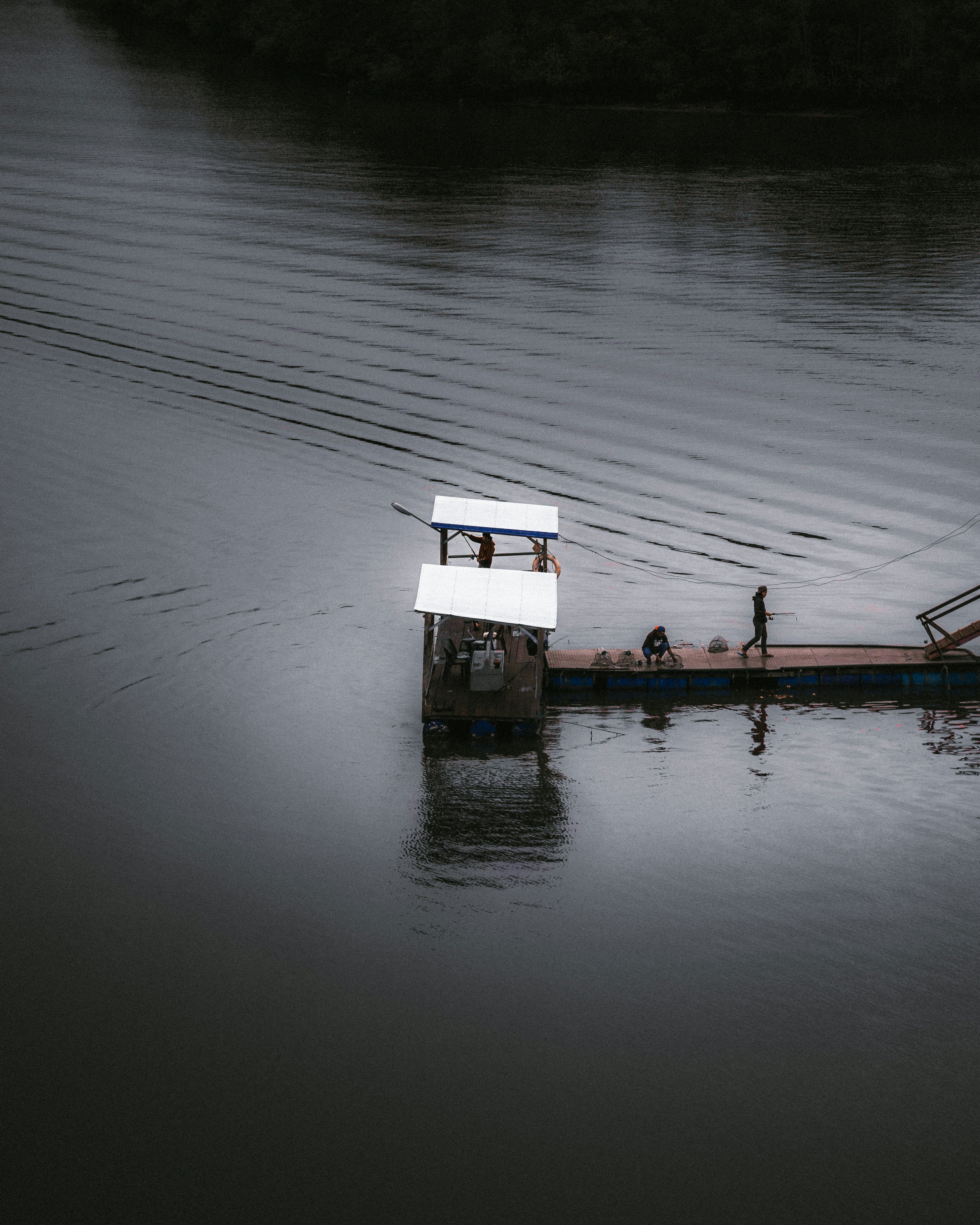 A small boat floating on top of a body of water photo – Free Fishing ...