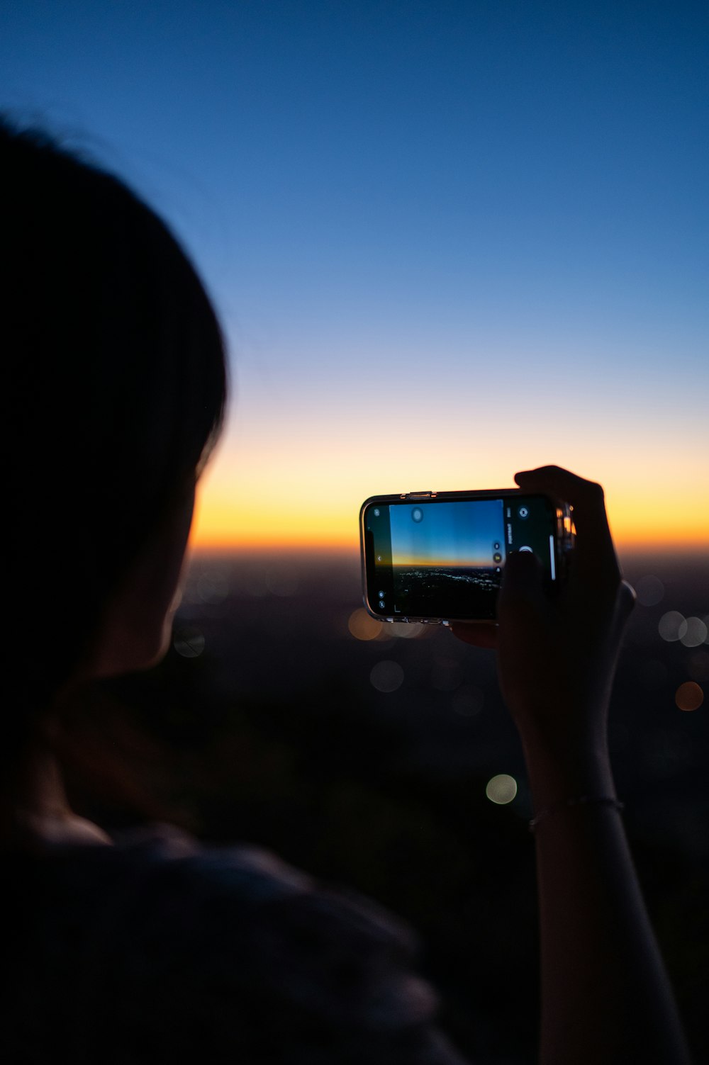 Une femme prenant une photo avec son téléphone portable