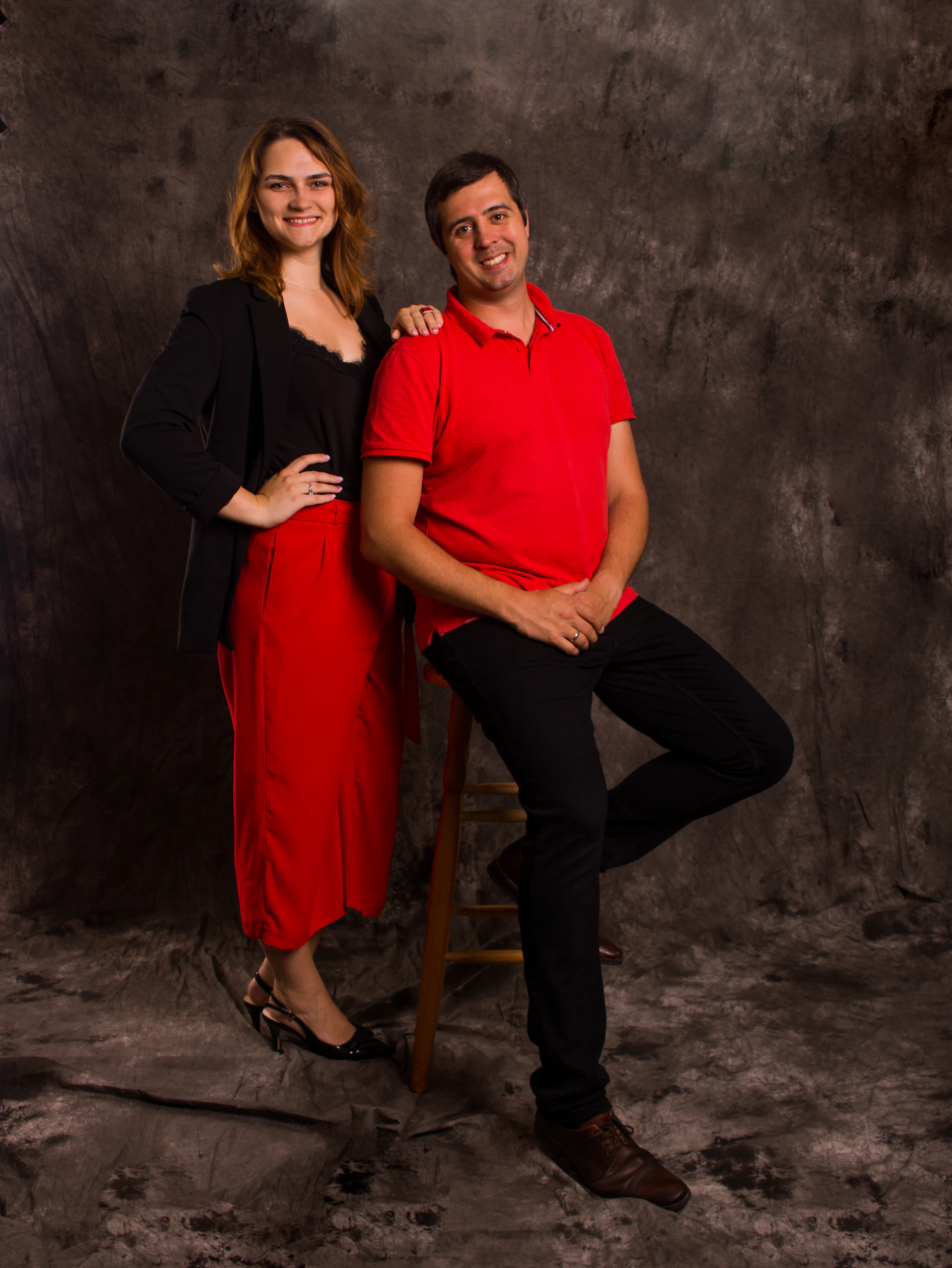 A stylish couple striking a pose in the classic studio booth with soft lighting highlighting their joyful expressions.