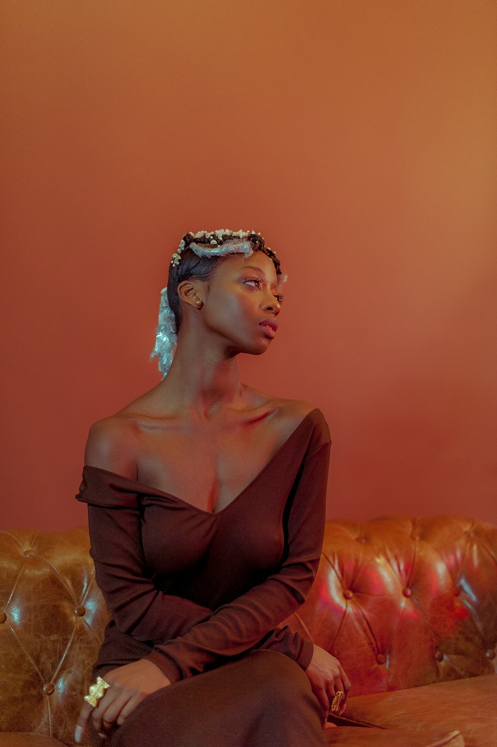 a woman sitting on top of a brown couch