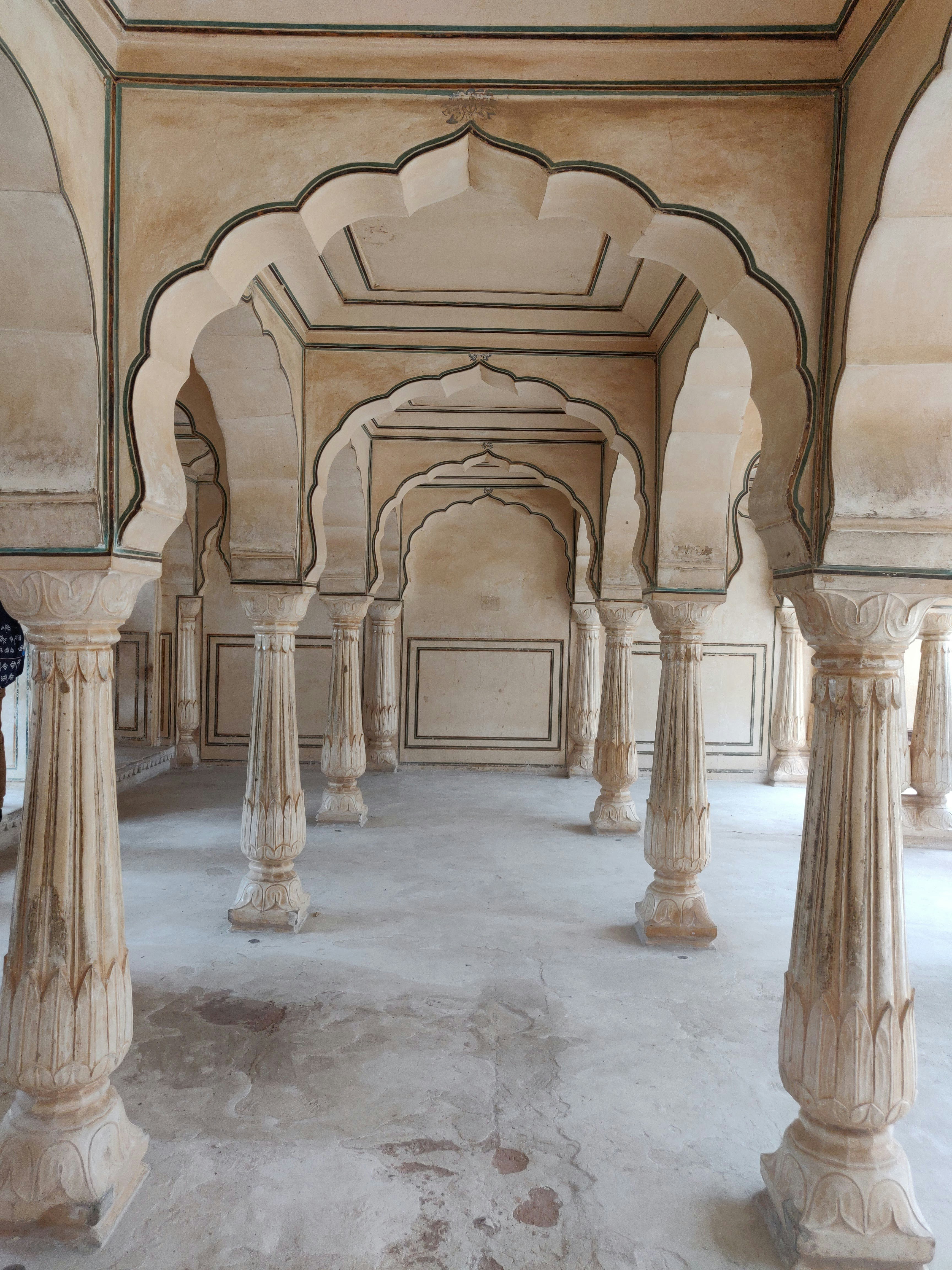 a large room with pillars and arches in it