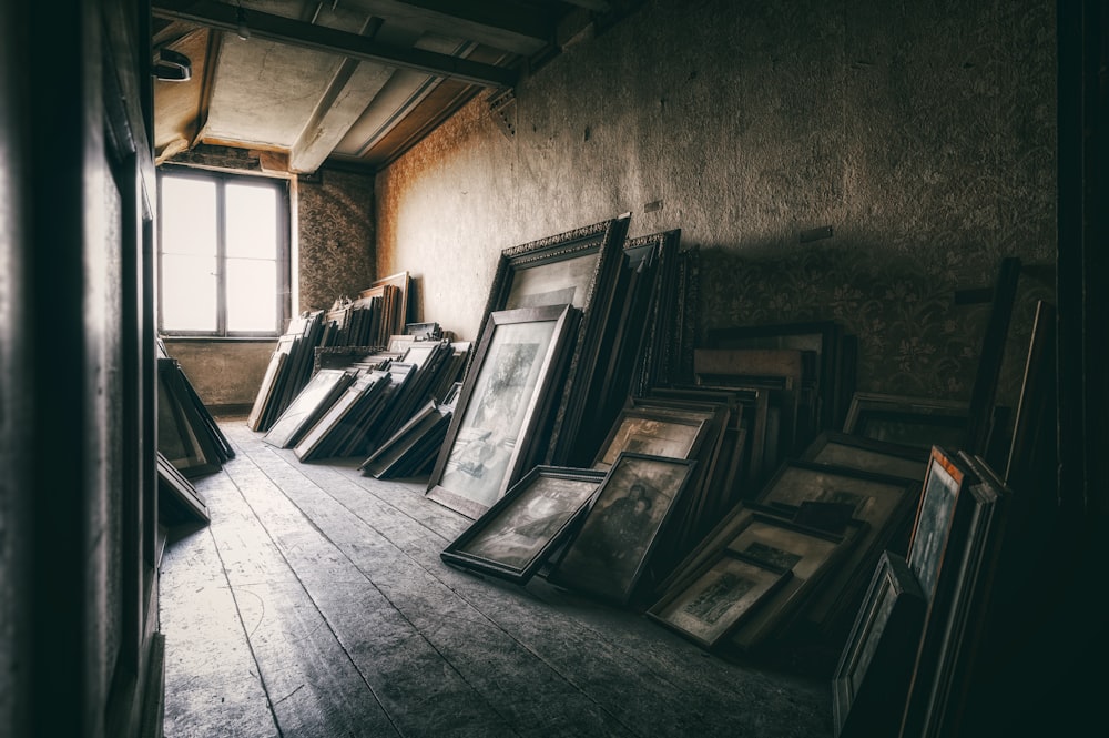 a room filled with lots of framed pictures next to a window