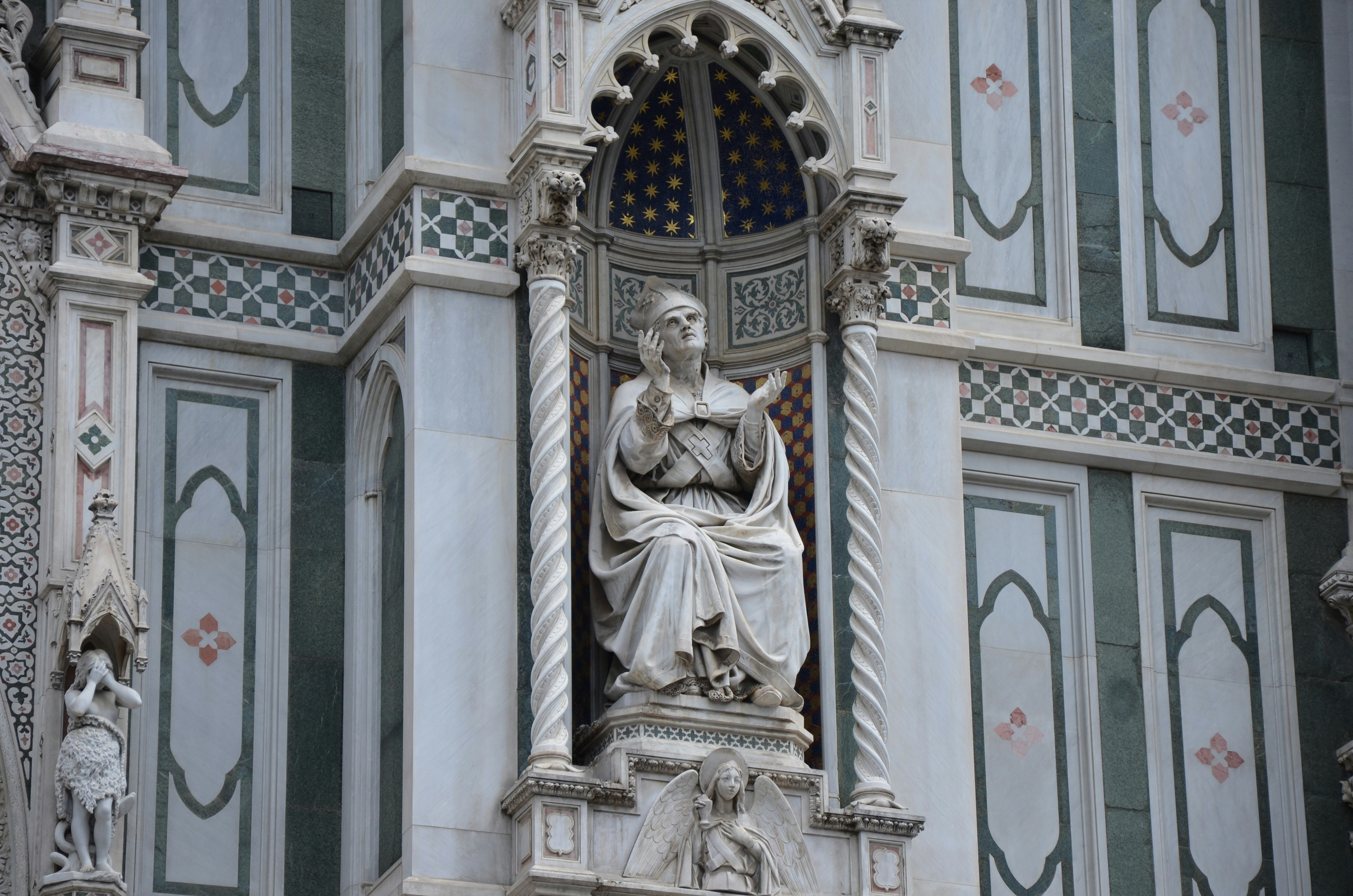 a statue of a woman on the side of a building