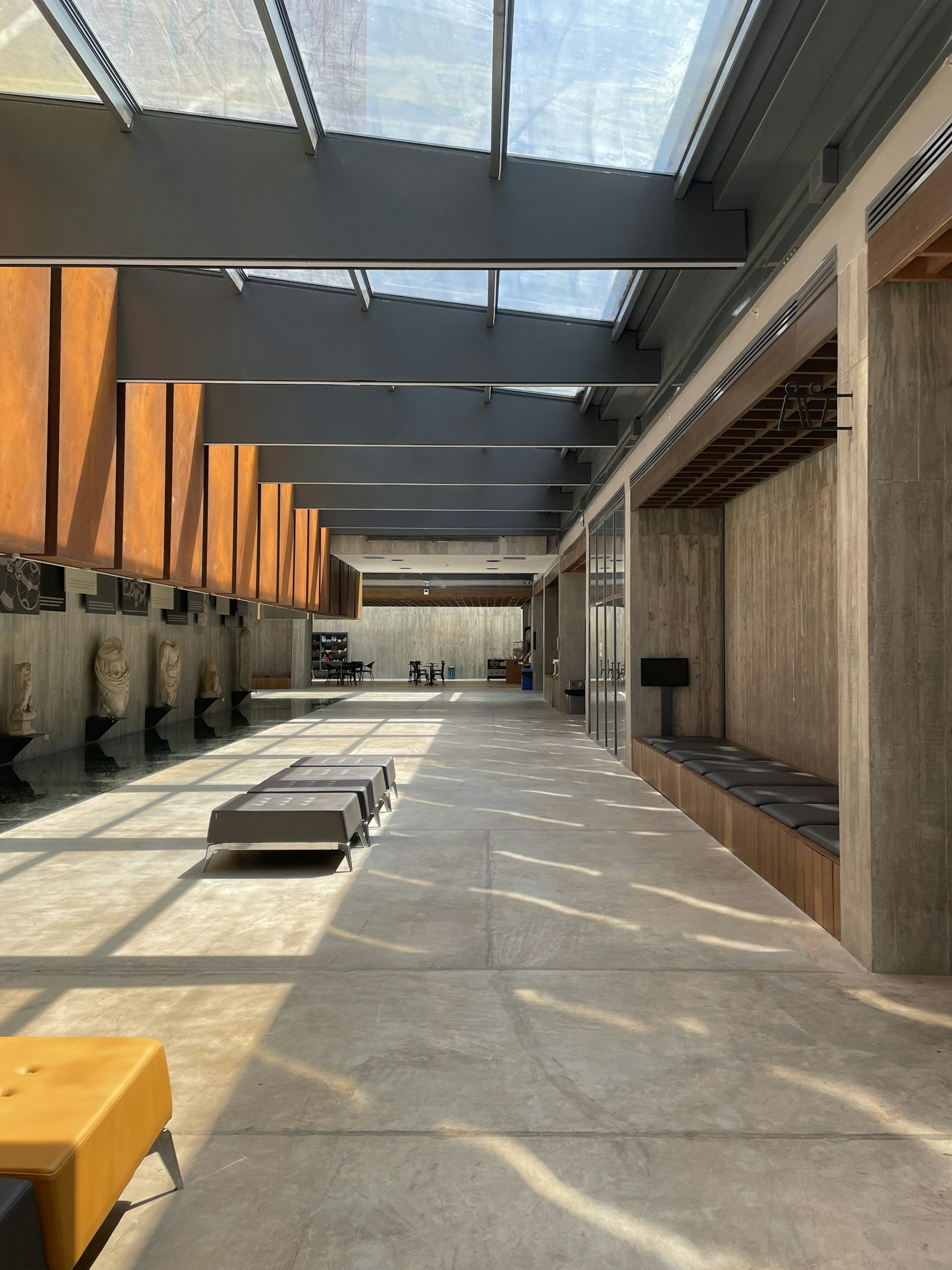 a long hallway with benches and a skylight