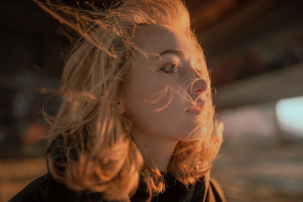 a woman with blonde hair blowing in the wind