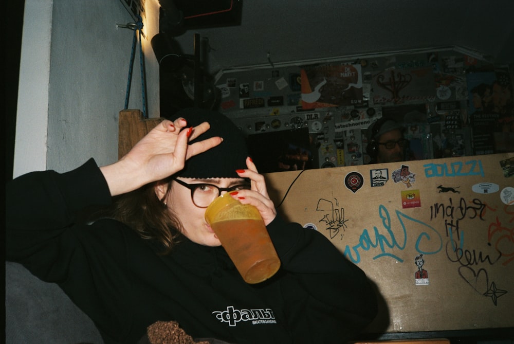 a woman drinking a bottle of orange juice