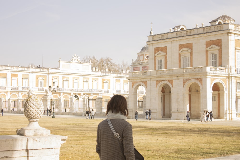 a woman standing in front of a large building