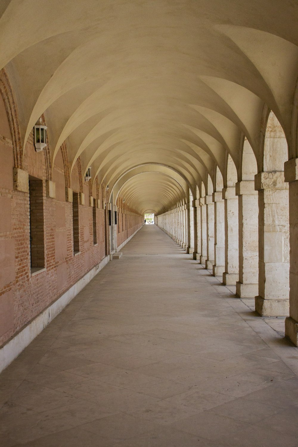 a long hallway with arches and a clock on the wall