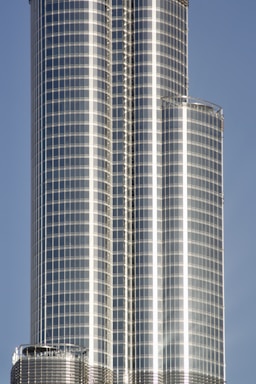 Sleek high-rise office tower with reflective glass facade in business district.