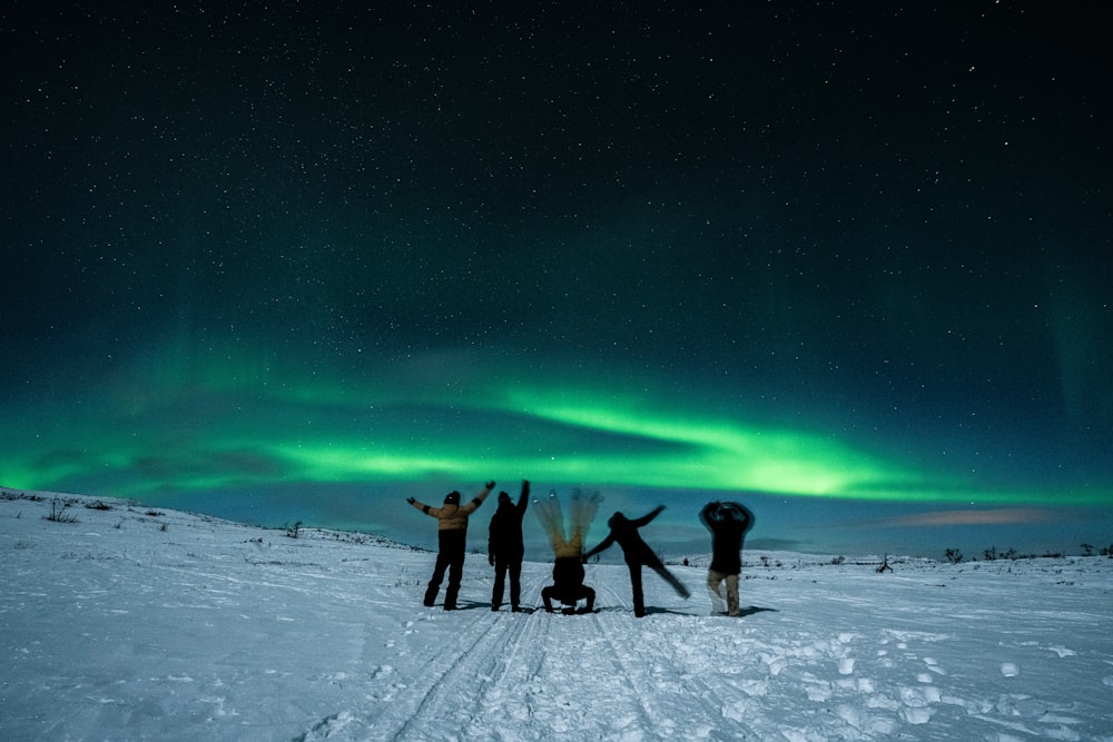 a group of people standing on top of a snow covered field