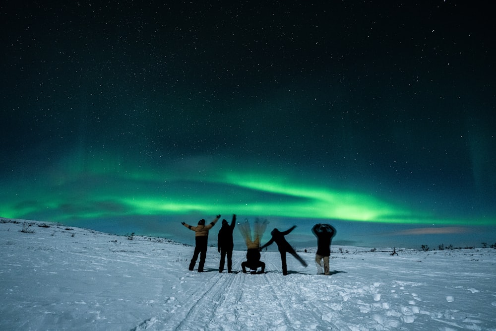 um grupo de pessoas em pé em cima de um campo coberto de neve